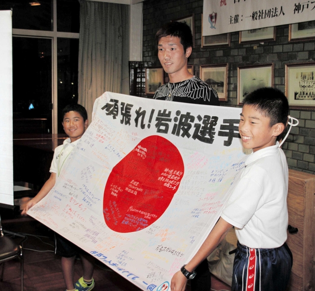 神戸ＦＣ主催の壮行会で寄せ書き入りの国旗を受け取る岩波拓也