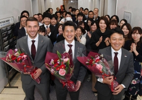 花束を手に笑顔を見せるヴィッセル神戸の（左から）ルーカス・ポドルスキ主将、吉田孝行監督、立花陽三社長＝神戸市中央区東川崎町１（撮影・中西大二）