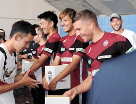 北海道地震の被災者支援を呼び掛けるポドルスキ（右）ら＝神戸市須磨区、ユニバー記念競技場