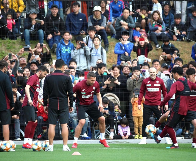 大勢の観衆が見つめる中、ボール回しをするダビド・ビジャ（手前左端）、ルーカス・ポドルスキ（同中央）、アンドレス・イニエスタ（同右から３人目）＝沖縄県金武町、金武町フットボールセンター（撮影・辰巳直之）