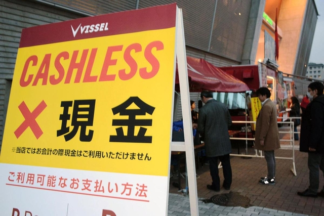 キャッシュレスを強調する立て看板。電子マネーのチャージ機にはファンらが列をつくった＝神戸市兵庫区御崎町１