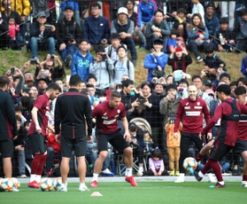 大勢の観衆が見つめる中、ボール回しをするダビド・ビジャ（手前左端）、ルーカス・ポドルスキ（同中央）、アンドレス・イニエスタ（同右から３人目）＝沖縄県金武町、金武町フットボールセンター（撮影・辰巳直之）