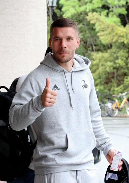 報道陣の呼び掛けにポーズを取る神戸のポドルスキ。謹慎が明けて練習に参加した＝神戸市西区、いぶきの森球技場