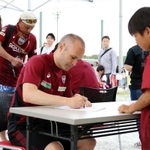 ファンの子どもにサインを書く神戸のイニエスタ（中央）＝神戸市西区、いぶきの森球技場