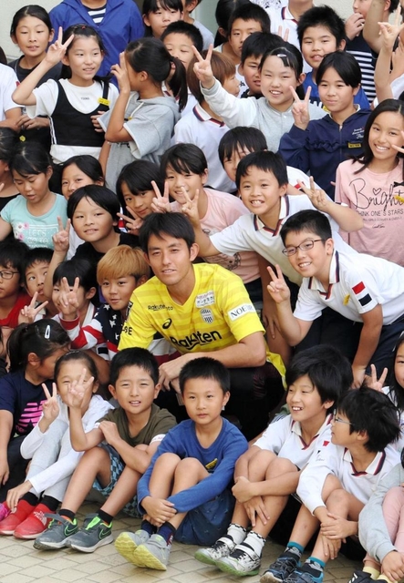黄色のユニホーム姿で集合写真に収まるＪ１神戸のＧＫ飯倉大樹＝神戸市兵庫区大開通４、兵庫大開小学校