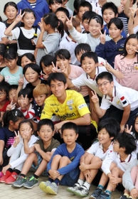 黄色のユニホーム姿で集合写真に収まるＪ１神戸のＧＫ飯倉大樹＝神戸市兵庫区大開通４、兵庫大開小学校