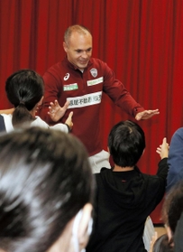 子どもたちに握手を求められながら会場を後にするＪ１神戸のイニエスタ選手＝神戸市須磨区大池町５、だいち小学校