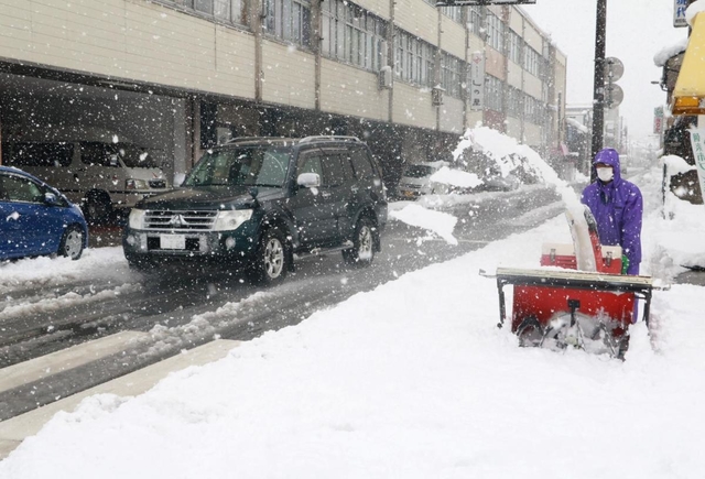 除雪機で歩道の雪をよける男性＝朝来市和田山町寺谷