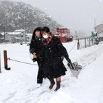 雪が積もった道を下校する高校生＝香美町香住区香住