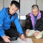 町職員から衛星電話の使い方について説明を受ける孤立集落の住民＝新温泉町高山