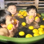 ユズを浮かべた露天風呂を楽しむ子どもたち＝豊岡市城崎町湯島、まんだら湯