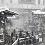 大雪の中、湯村温泉の人気スポット「荒湯」を観光する旅行客＝３１日午前３５分、新温泉町湯、湯村温泉