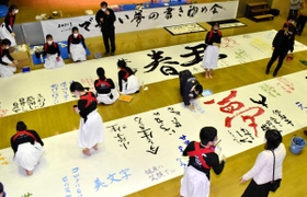 大きな和紙に新年の目標や夢をつづる参加者＝おおやホール