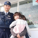 青倉駐在所勤務員の安達弘さん（左）と妻の奈津美さん。駐在所入り口のガラスにもかわいらしい絵が描かれている＝朝来市物部