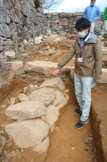 大手道の地中から新たに見つかった石積みの説明をする朝来市教育委員会文化財課の大川拓也さん＝竹田城跡
