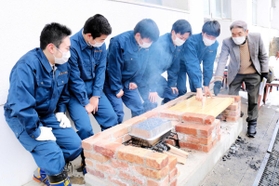 「防災かまどベンチ」の使い方を説明する生徒たち＝豊岡市加広町