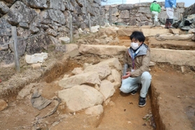 大手道の地中から新たに見つかった石積みの説明をする朝来市教育委員会文化財課の大川拓也さん＝竹田城跡