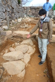 大手道の地中から新たに見つかった石積みの説明をする朝来市教育委員会文化財課の大川拓也さん＝竹田城跡
