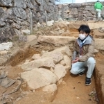 大手道の地中から新たに見つかった石積みの説明をする朝来市教育委員会文化財課の大川拓也さん＝竹田城跡