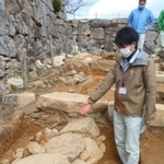 大手道の地中から新たに見つかった石積みの説明をする朝来市教育委員会文化財課の大川拓也さん＝竹田城跡