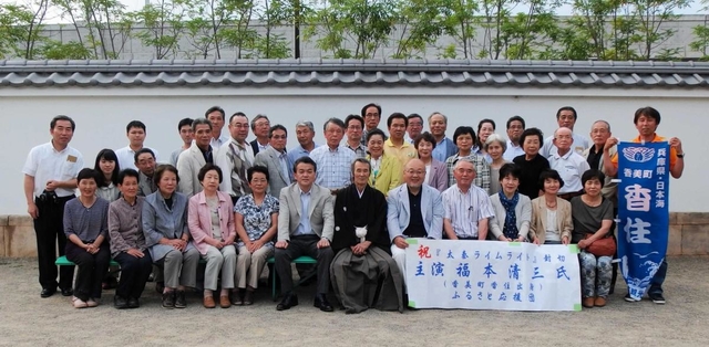主演映画「太秦ライムライト」が京都で公開された初日、香美町から駆け付けた住民らと写真に収まる福本清三さん（前列中央）＝京都市右京区太秦東蜂岡町、東映太秦映画村（香美町提供）