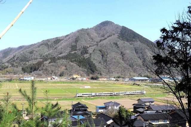 豊岡市と養父市の境にそびえる須留岐山を背景に快走する特急「こうのとり」＝養父市内
