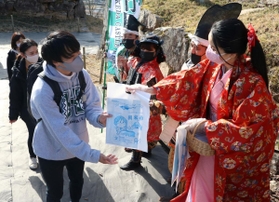 姫や武士に分した市職員らから記念品を受け取る観光客＝竹田城跡