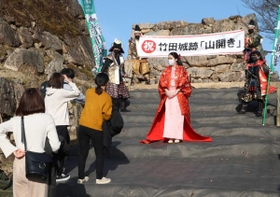 姫や甲冑姿に扮した市職員らから歓迎を受けた来城者＝竹田城跡