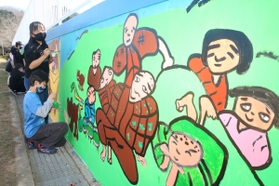 プールの壁に「じろはったん」の絵を描く児童たち＝大蔵小学校