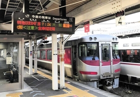 出発を待つ特急「はまかぜ」。自由席廃止で全車指定席となったことを知らせる駅の案内板＝ＪＲ豊岡駅