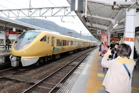 明智光秀のラッピング電車「こうのとり」。観光客がカメラを向ける＝１３日午後３時ごろ、ＪＲ城崎温泉駅
