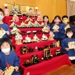 原證さんが寄贈した七段飾りと園児たち＝長井幼稚園