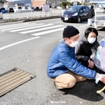 事故のあった交差点で花を供える和田小百合さんと哲治さん＝豊岡市中陰
