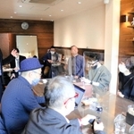 かばんメーカー、コニーの西田正樹社長（左）から話を聞く参加者たち＝豊岡市城崎町湯島