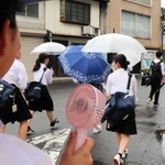 夏場は「手持ち扇風機」も活用して歩く＝養父市八鹿町八鹿、２０２０年７月７日