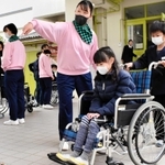 児童に車いす利用者への介助方法を教える高校生ら＝日高高