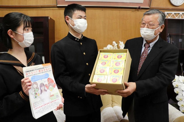 未成年の飲酒防止を訴え、高校生に啓発グッズを手渡す松元襄司さん（右端）＝浜坂高校