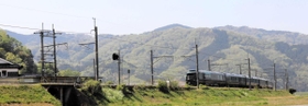 新緑が美しい里山の中を疾走する豪華寝台列車「トワイライトエクスプレス瑞風」＝養父市八鹿町宿南