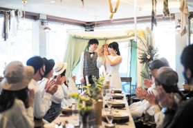 パーティーで指輪を交換する渡部悠介さん（左）と寺岡美加さんに拍手を送るキャンプ仲間たち（アーススタジオ提供）＝香美町村岡区大笹