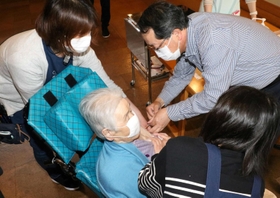 入所者に新型コロナウイルスのワクチンを接種する医師（右）＝あさがおホール