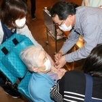 入所者に新型コロナウイルスのワクチンを接種する医師（右）＝あさがおホール