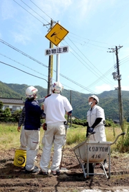 コウノトリ注意の警戒標識を設置する作業員＝朝来市和田山町白井