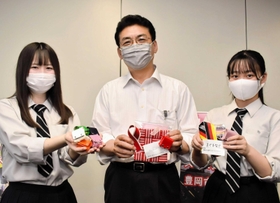 ドイツとスイスの代表チームへの記念品を関貫久仁郎豊岡市長（中央）に手渡した生徒たち＝豊岡市役所