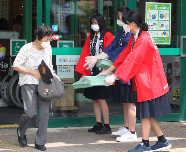 買い物客にグッズを配って選挙の投票を呼び掛ける豊岡総合高の生徒たち＝コープデイズ豊岡