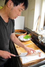 ケンサキイカの生き造りを調理する料理人＝香美町香住区下浜