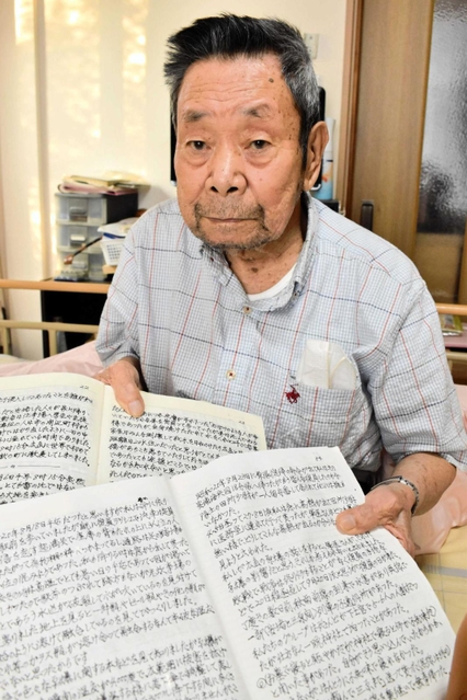 記録をしたためたノートを手にする藤本治憲さん＝豊岡市下陰