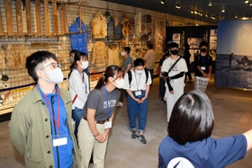 展示物の説明を受ける学生ら＝植村直己冒険館
