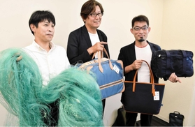 廃棄される漁網（左）を再利用した生地を使用したかばんを製造した兵庫県鞄工業組合のメンバー＝豊岡市役所
