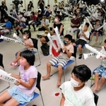 中継映像を見ながら応援する地元住民ら＝三江地区コミュニティセンター