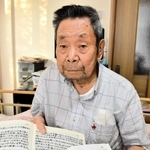記録をしたためたノートを手にする藤本治憲さん＝豊岡市下陰